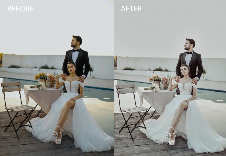 May include: A bride and groom pose for a wedding photo in front of a pool. The bride is wearing a white wedding dress with a high slit and the groom is wearing a black tuxedo. They are standing next to a table with flowers and a chair.
