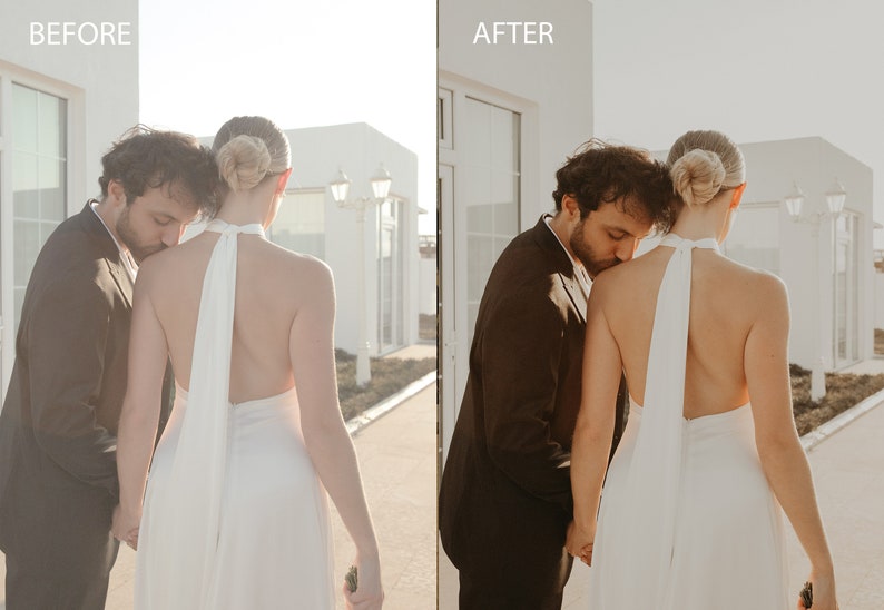 May include: A couple in wedding attire, the groom is kissing the bride's shoulder. The bride is wearing a white halter dress with a long flowing sash. The groom is wearing a black suit. The couple is standing in front of a white building with a door.