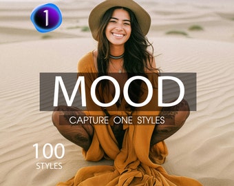 May include: A woman wearing a brown hat and a long, flowing, mustard yellow dress sits in a desert landscape. The text "MOOD" and "CAPTURE ONE STYLES" is displayed in white letters on a black background. The number "100" is displayed in white letters on a black background with the word "STYLES" below it.