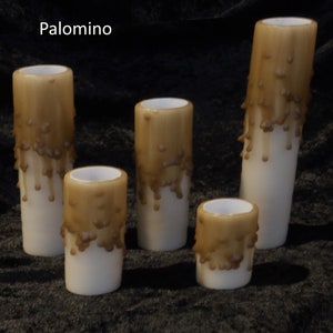 May include: Five brown dripped candles of varying sizes. The candles are white with a brown wax drip pattern. The candles are on a dark brown surface. The word "Palomino" is written in white text at the top of the image.
