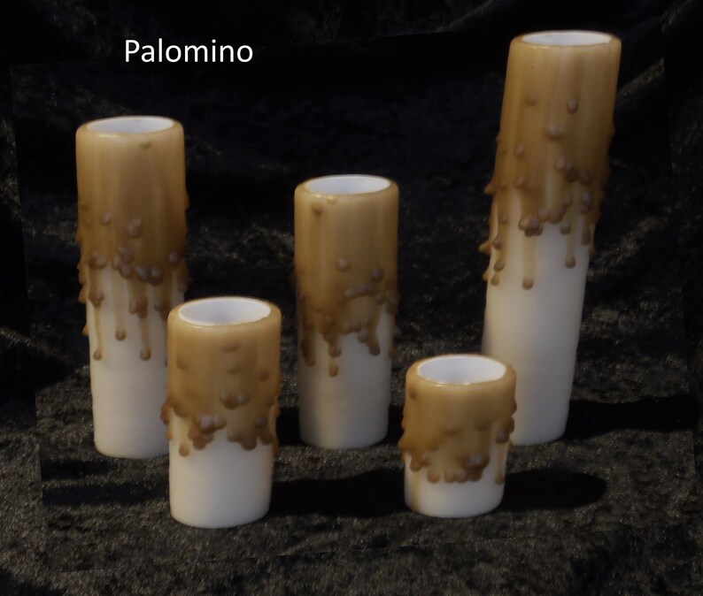 May include: Five brown dripped candles of varying sizes. The candles are white with a brown wax drip pattern. The candles are on a dark brown surface. The word "Palomino" is written in white text at the top of the image.