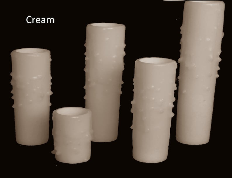 May include: Five cream-colored pillar candles with a textured surface. The candles are of varying heights.