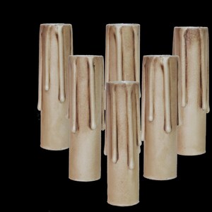 May include: Set of six beige candle sleeves with a drippy wax design. The sleeves are made of a textured material and are designed to fit over a standard candle.