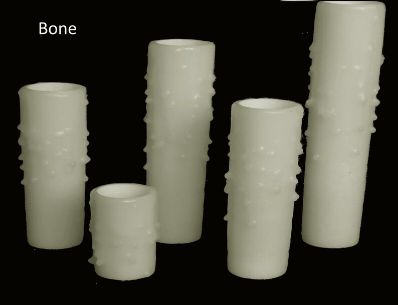 May include: Five white candles with a textured surface. The candles are different sizes and are arranged in a row. The text "Bone" is visible in the top left corner of the image.