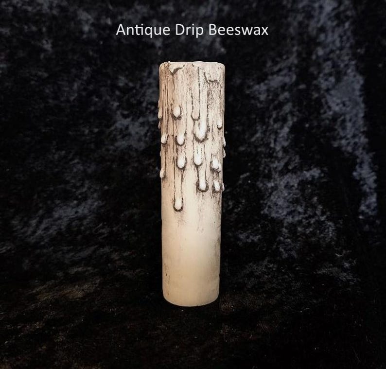 May include: Antique drip beeswax candle with a white and brown color scheme. The candle has a textured surface with a drip design.