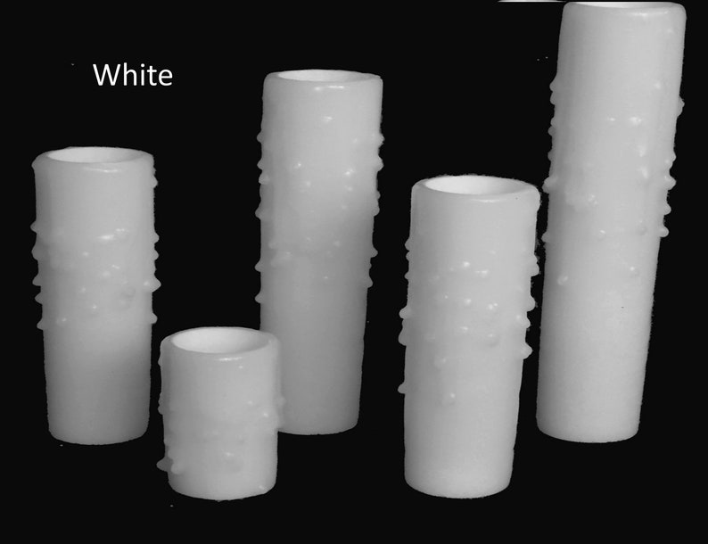 May include: Five white pillar candles with a textured surface. The candles are different sizes and are arranged in a row. The text "White" is visible in the top left corner of the image.