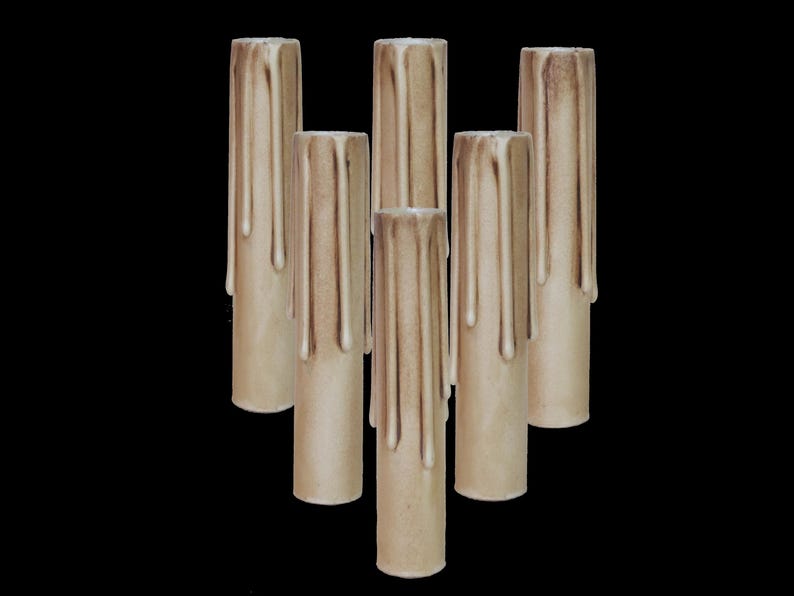 May include: Six beige taper candles with dripped wax, perfect for adding a rustic touch to your home decor.