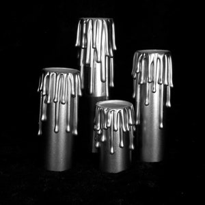 May include: Four silver candle holders with a dripping wax design. The candle holders are arranged in a pyramid shape.
