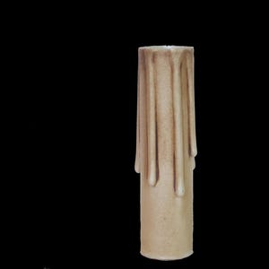 May include: A beige candle with a drippy design. The candle is made of wax and has a smooth surface.