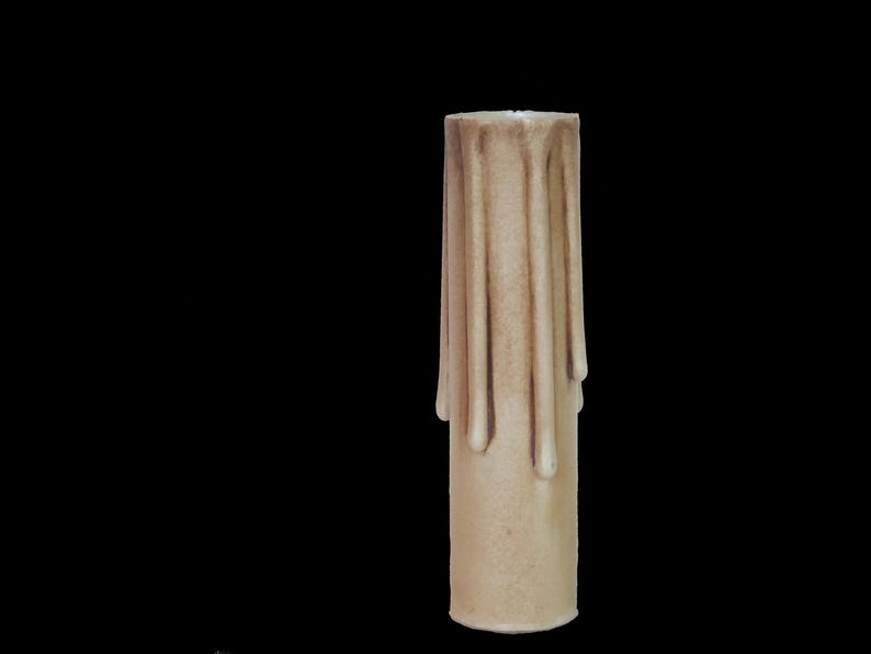 May include: A beige candle with a drippy design. The candle is made of wax and has a smooth surface.
