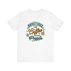 May include: White t-shirt with a blue and yellow graphic that says "Sometimes I like coffee more than people".