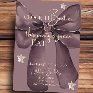 May include: A rectangular invitation card with a watercolor-style purple bow and text. The text reads "Clock it Bestie, this party's gonna EAT" and "Ashley's Birthday" with date, time, address, and RSVP information.