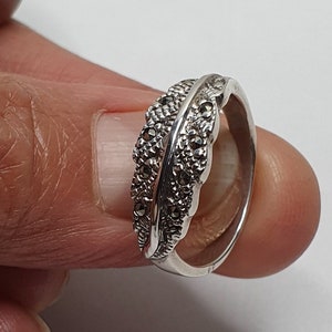 Könnte beinhalten: Ein silberner Ring mit einem Federdesign, besetzt mit Markasiten.