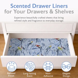 May include: A white drawer with a blue patterned drawer liner featuring birds and foliage. The text at the top reads "Scented Drawer Liners for Your Drawers & Shelves". The liner has a refined finish, long-lasting scent, is non-adhesive, and has an elegant design.