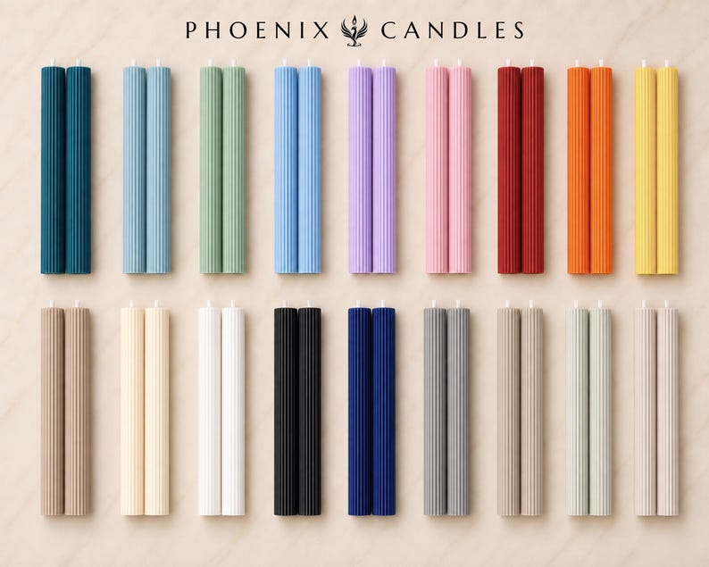 a collection of 16 candles in various colors and shapes, arranged in a grid-like pattern on a light-colored background.