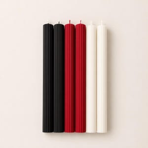 five candles of different colors: black, red, white, and two additional colors that are not visible in the image.