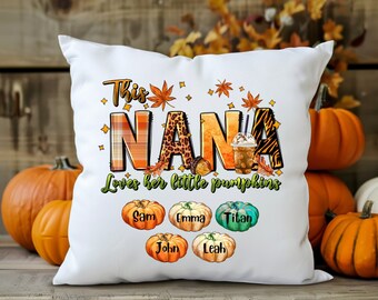 May include: White throw pillow with the text "This Nana Loves her little pumpkins" and a fall-themed design. The pillow features a coffee cup, leaves, and pumpkins with the names Sam, Emma, Titan, John, and Leah.