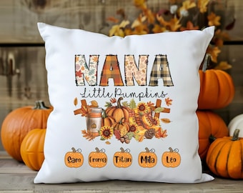 May include: White throw pillow with the text "NANA little pumpkins" in orange, brown, and black. The pillow features a fall-themed design with pumpkins, sunflowers, and leaves. The names "Sam, Emma, Titan, Mila, Leo" are printed in a circle around the bottom of the pillow.