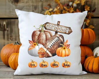 May include: White throw pillow with a football, pumpkins, and a sign that says "Grandma". The pillow also has the names Leo, Sam, Alex, and John printed on it.