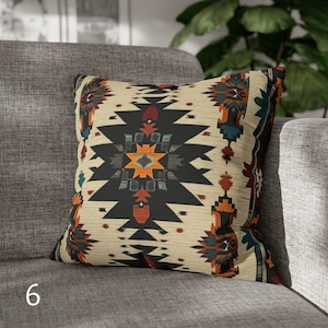 May include: A throw pillow with a geometric pattern in shades of black, orange, red, blue, and white. The pattern is reminiscent of Native American art.