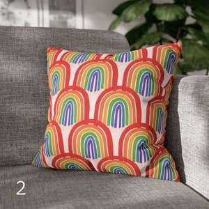 May include: A throw pillow with a colorful rainbow pattern. The pillow is made of a soft, comfortable fabric and features a repeating design of multi-colored rainbows.