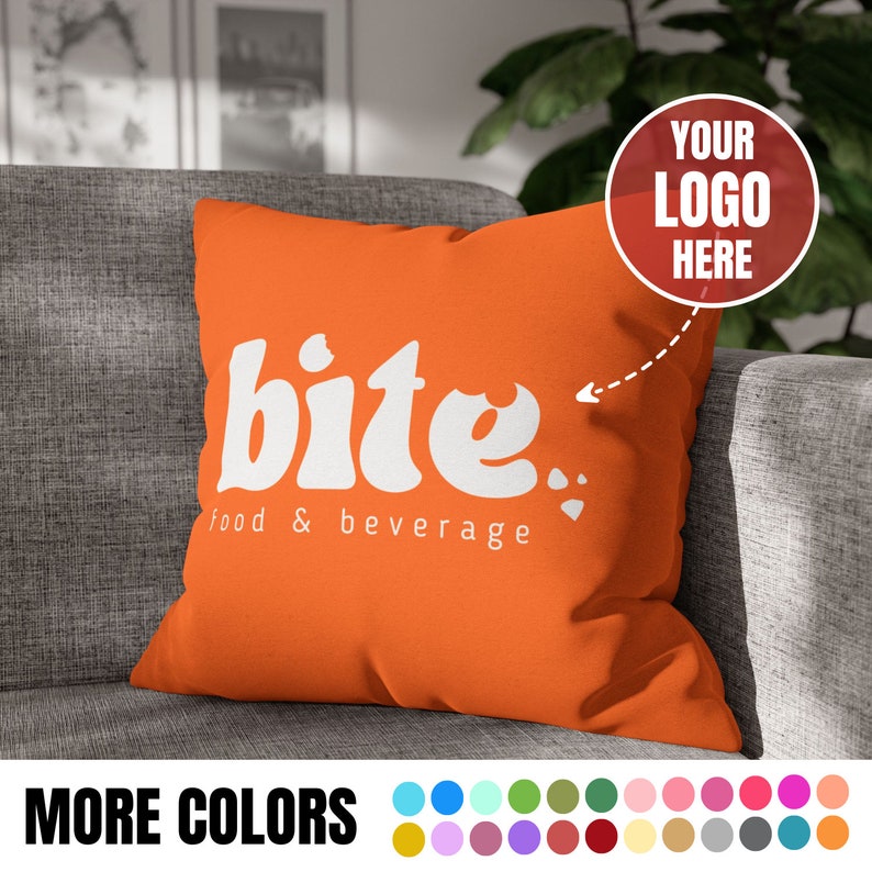 May include: Orange throw pillow with the text "bite." and "food & beverage" in white. A red circle with the text "YOUR LOGO HERE" is in the upper right corner of the image.