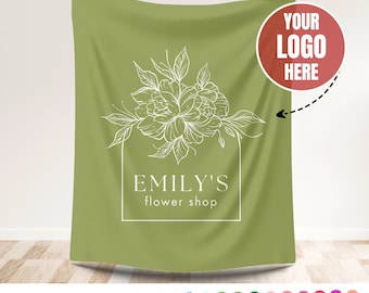 Może przedstawiać: Zielone tło z tkaniny z białym wzorem kwiatowym i tekstem "Emily's flower shop". Czerwone koło z tekstem "Your Logo Here" znajduje się w prawym górnym rogu.