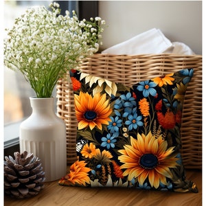 Puede incluir: Una almohada decorativa con un patr&oacute;n floral que presenta girasoles, flores azules y hojas verdes sobre un fondo negro.
