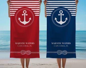 May include: Two beach towels with a nautical theme. Both towels feature a white anchor in a rope circle on a blue and white striped background. The top towel is red with white stripes and the bottom towel is blue with white stripes. Both towels have the text "Majestic Waters Cape Coral, FL" printed on them.