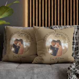 Pode incluir: Duas almofadas de sof&aacute; bege com uma foto de um casal em um c&iacute;rculo e o texto "Happy 5th Anniversary" e "Lars & Olivia".