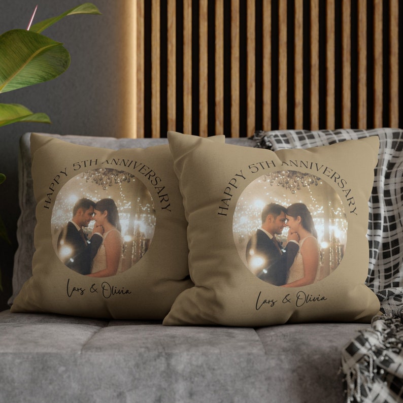 Pode incluir: Duas almofadas de sof&aacute; bege com uma foto de um casal em um c&iacute;rculo e o texto "Happy 5th Anniversary" e "Lars & Olivia".