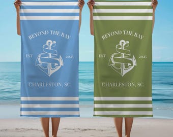 May include: Two beach towels with white stripes and the text "Beyond the Bay" in white. The towels have a white anchor design and the text "Est 2025" and "Charleston, SC". One towel is blue and the other is green.