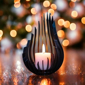 May include: A black metal candle holder with a geometric design, holding a white candle. The candle holder is on a reflective surface with a blurred background of lights.