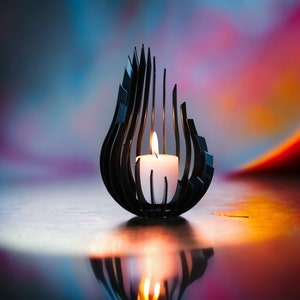 May include: A black metal candle holder shaped like a flame with a white candle inside. The candle is lit and the flame is casting a warm glow. The background is a blurred out colorful gradient of blue, pink, and orange.