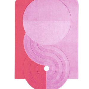 May include: A pink and red abstract rug with a circular design. The rug has a unique shape with a curved top and bottom.