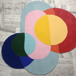 May include: A colorful abstract rug with overlapping circles in shades of blue, green, pink, yellow, orange, and red.