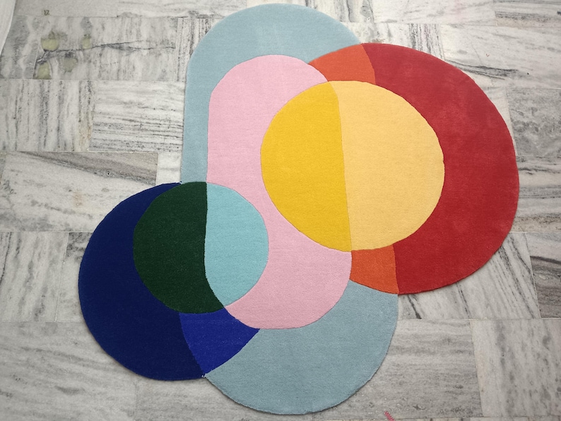 May include: A colorful abstract rug with overlapping circles in shades of blue, green, pink, yellow, orange, and red.