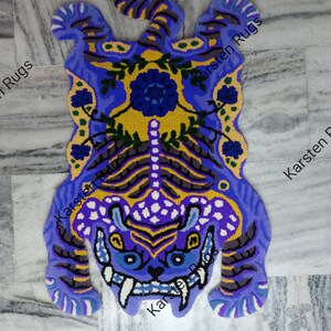 May include: A blue and yellow tiger rug with floral details. The rug is made of wool and has a shaggy texture.