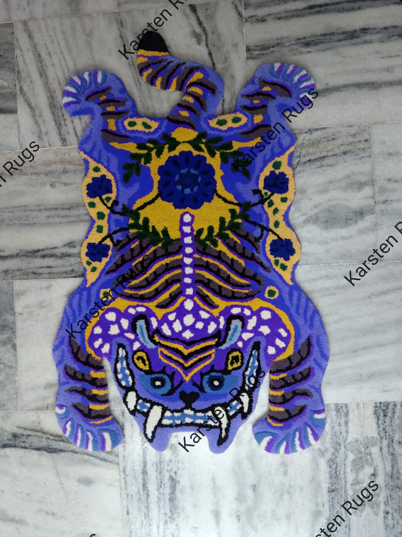 May include: A blue and yellow tiger rug with floral details. The rug is made of wool and has a shaggy texture.