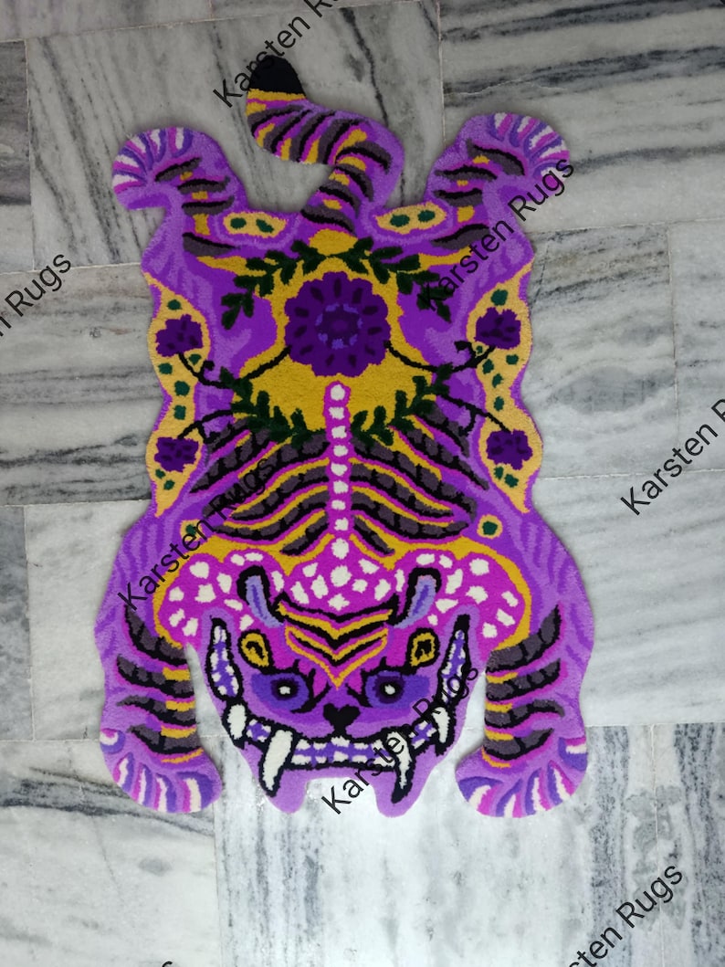 May include: A purple and yellow tiger rug with a floral design. The rug is made of a soft, plush material and has a detailed design.