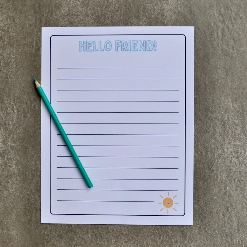 May include: A lined notepad with the text "HELLO FRIEND!" in light blue. A small, smiling sun graphic is in the bottom right corner. A teal pencil rests diagonally across the notepad.