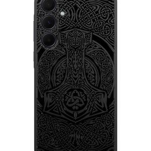 May include: Black phone case with a detailed design of a hammer and intricate knotwork. The design is in a dark gray color and has a 3D effect.