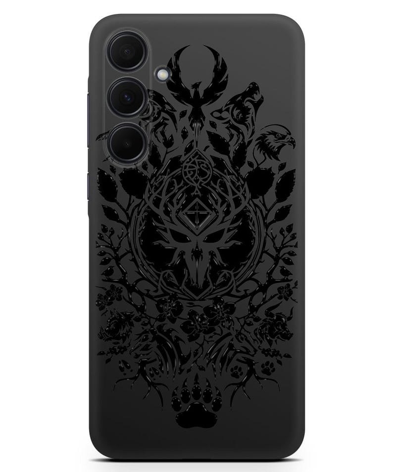 Puede incluir: Carcasa de tel&eacute;fono negra con un dise&ntilde;o detallado de un animal estilizado con alas, un p&aacute;jaro y un lobo. El dise&ntilde;o est&aacute; rodeado de elementos florales y una cruz.