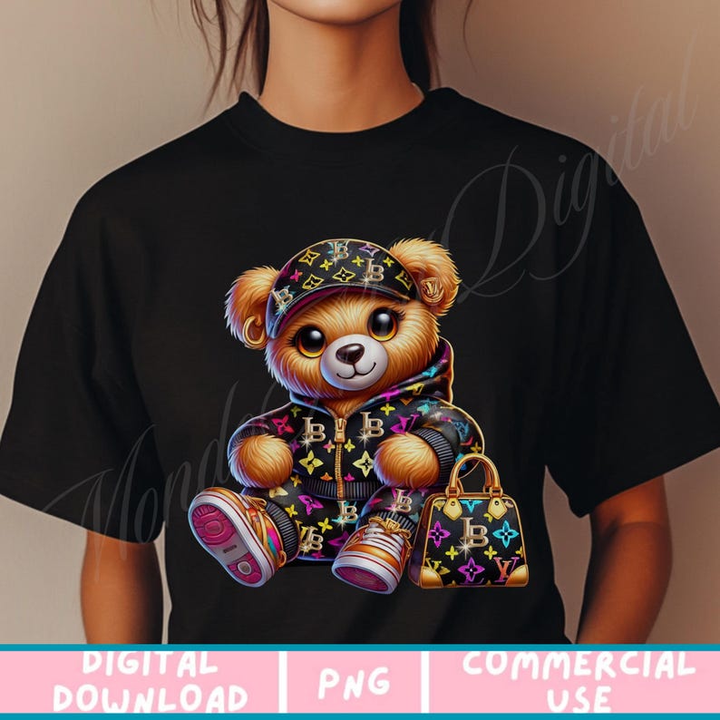 May include: A black t-shirt with a cartoon teddy bear wearing a black and gold patterned outfit and a black and gold patterned hat. The teddy bear is holding a black and gold patterned handbag.