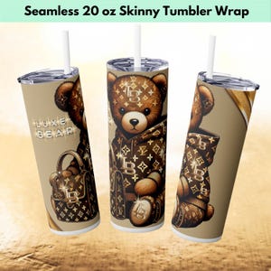 May include: A 20 ounce skinny tumbler wrap featuring a brown teddy bear wearing a brown and gold patterned jacket and holding a brown and gold patterned handbag. The background is a light brown with a gold pattern.