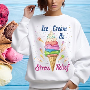 Può includere: Felpa bianca con un'immagine di un cono gelato colorato e il testo "Ice Cream & Stress Relief".