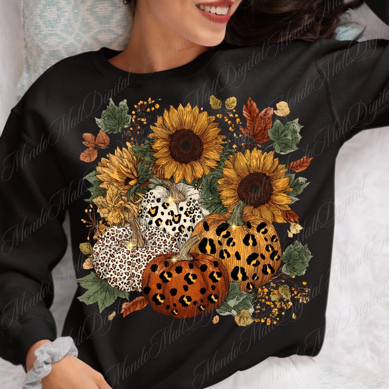 May include: Black sweatshirt featuring a fall-themed design. The design includes sunflowers, pumpkins with leopard print patterns, and autumn foliage. The sunflowers are yellow and brown, and the pumpkins are orange, white, and brown.