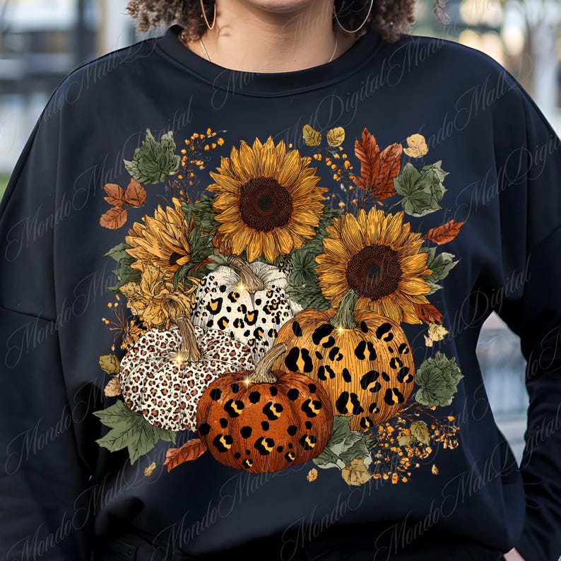 May include: Black sweatshirt featuring a fall-themed design. The design includes sunflowers, pumpkins with leopard print patterns, and autumn leaves. The overall color palette is warm, with shades of orange, yellow, and brown.