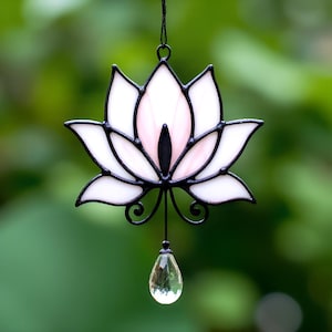 May include: A stained glass lotus flower suncatcher with a pink center and a clear crystal drop hanging from the bottom.