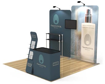 May include: A trade show booth with a blue and white backdrop featuring the logo "Omorovicza Budapest". The booth includes a counter, a shelf unit, a brochure holder, and a TV screen.